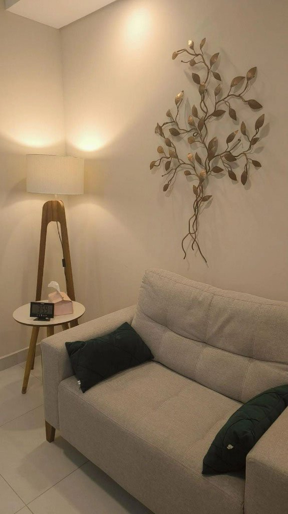 Sofá, luminária e decoração na sala de atendimento do consultório em Campinas